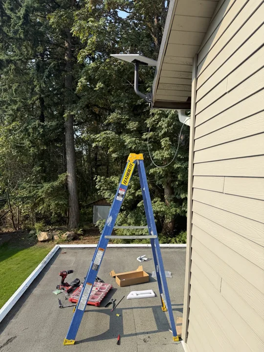 Ladder and tools during a Starlink installation beside a house