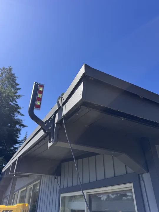 Spirit level used to align a Starlink mounting bracket at the roof edge
