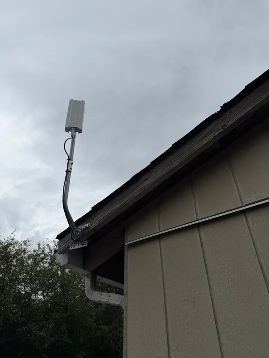 Starlink dish on an extended mount at the roof edge
