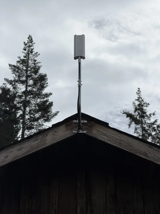 Starlink dish on a pole above a cabin roof