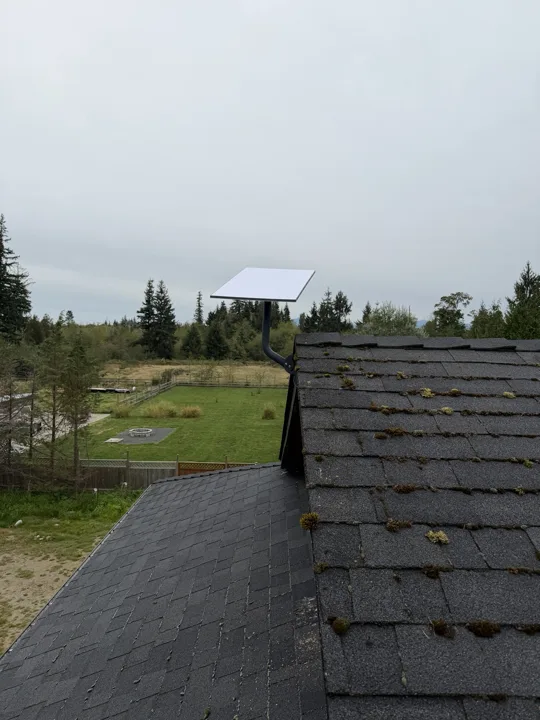 Starlink dish on a roof-edge mount overlooking a rural property